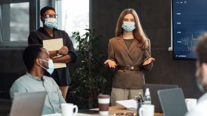 woman chairing meeting with mask
