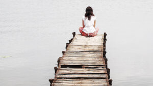 Person sitting at end of pier